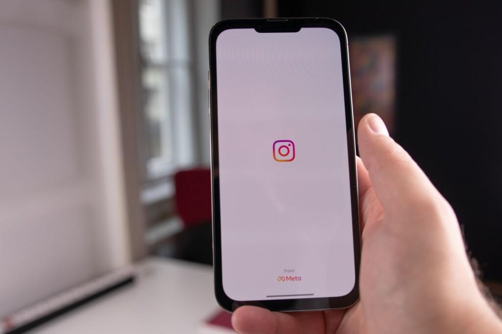 Käsi pitelee puhelinta, jossa näkyy Instagramin logo.
